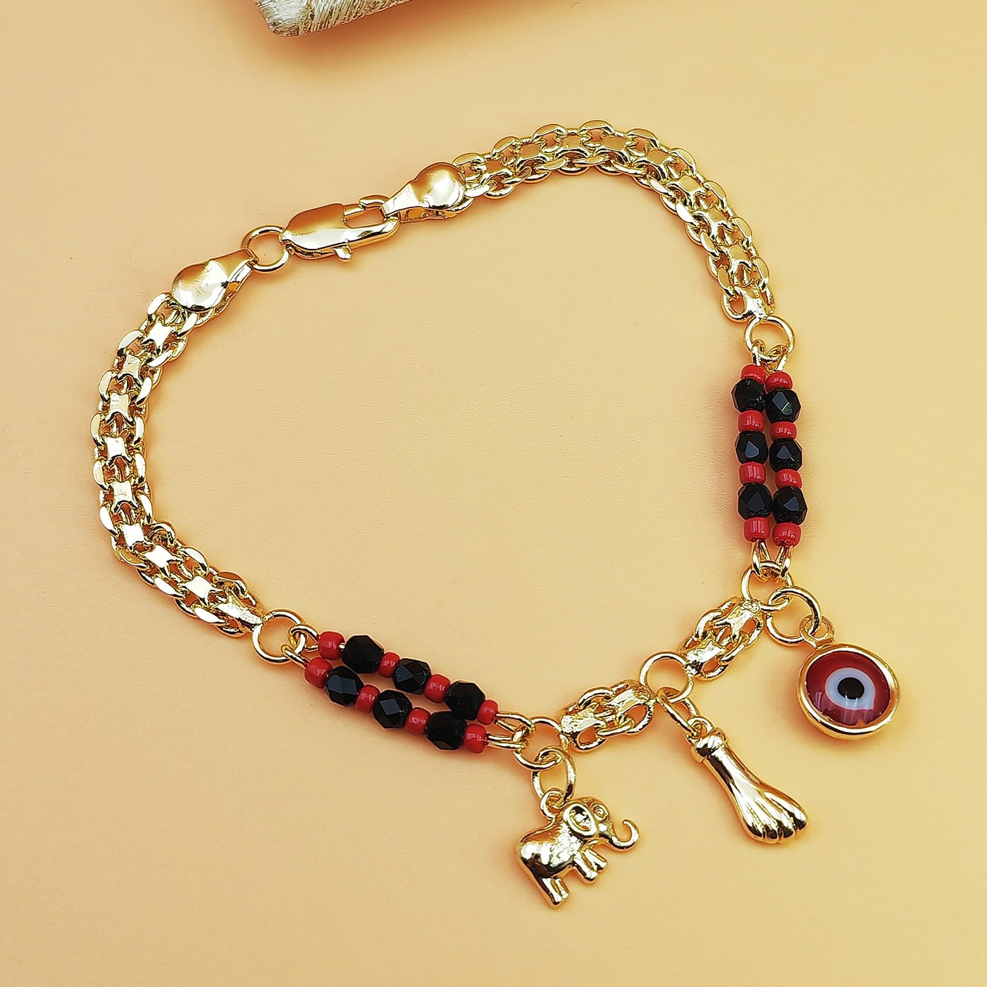 Gold-Tone Chain Bracelet with Red and Black Beads, Elephant Charm, Feather